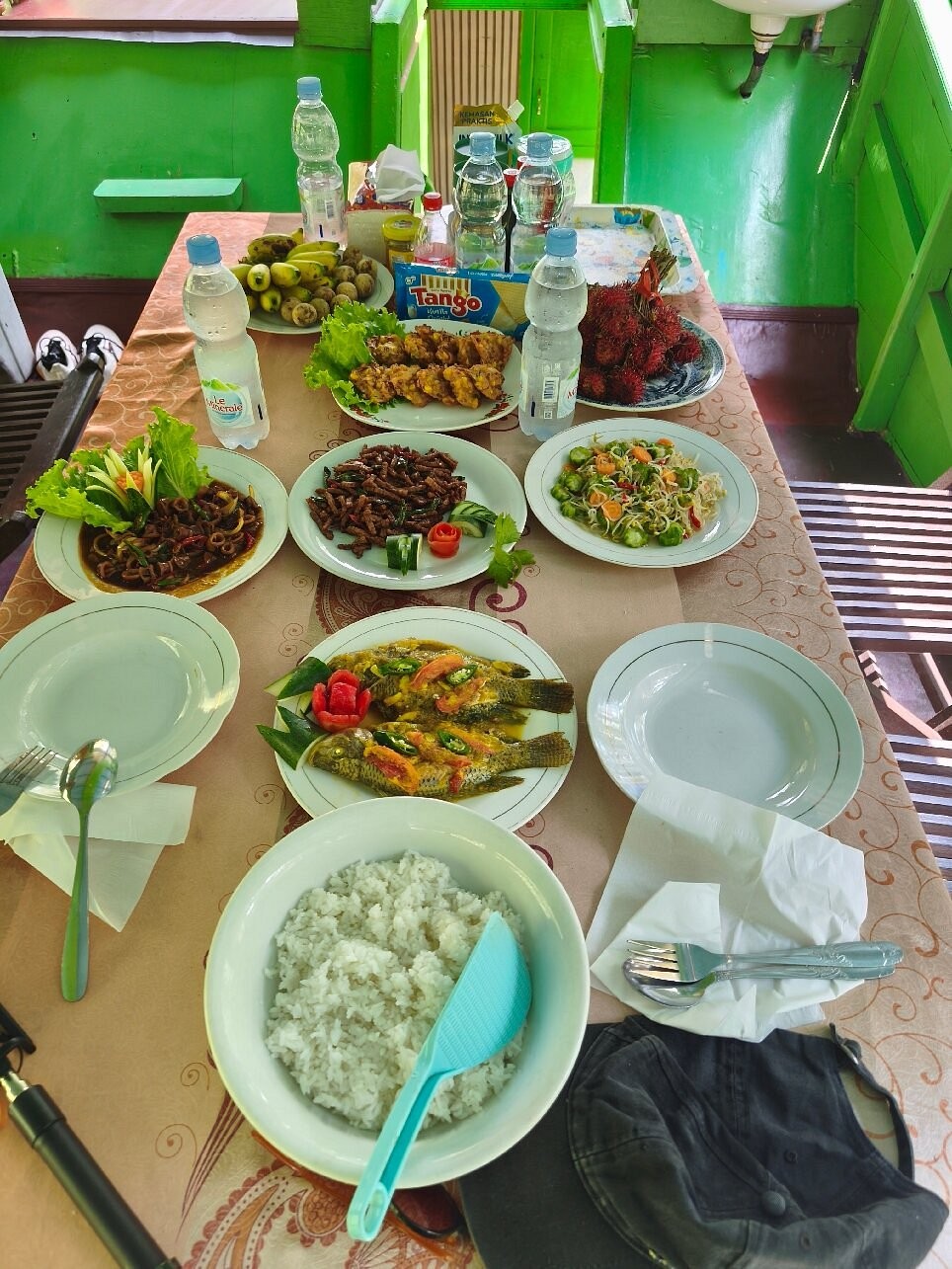 Hidangan lengkap masakan Indonesia di klotok - ikan, sayur, rambutan, dan masih banyak lagi.
