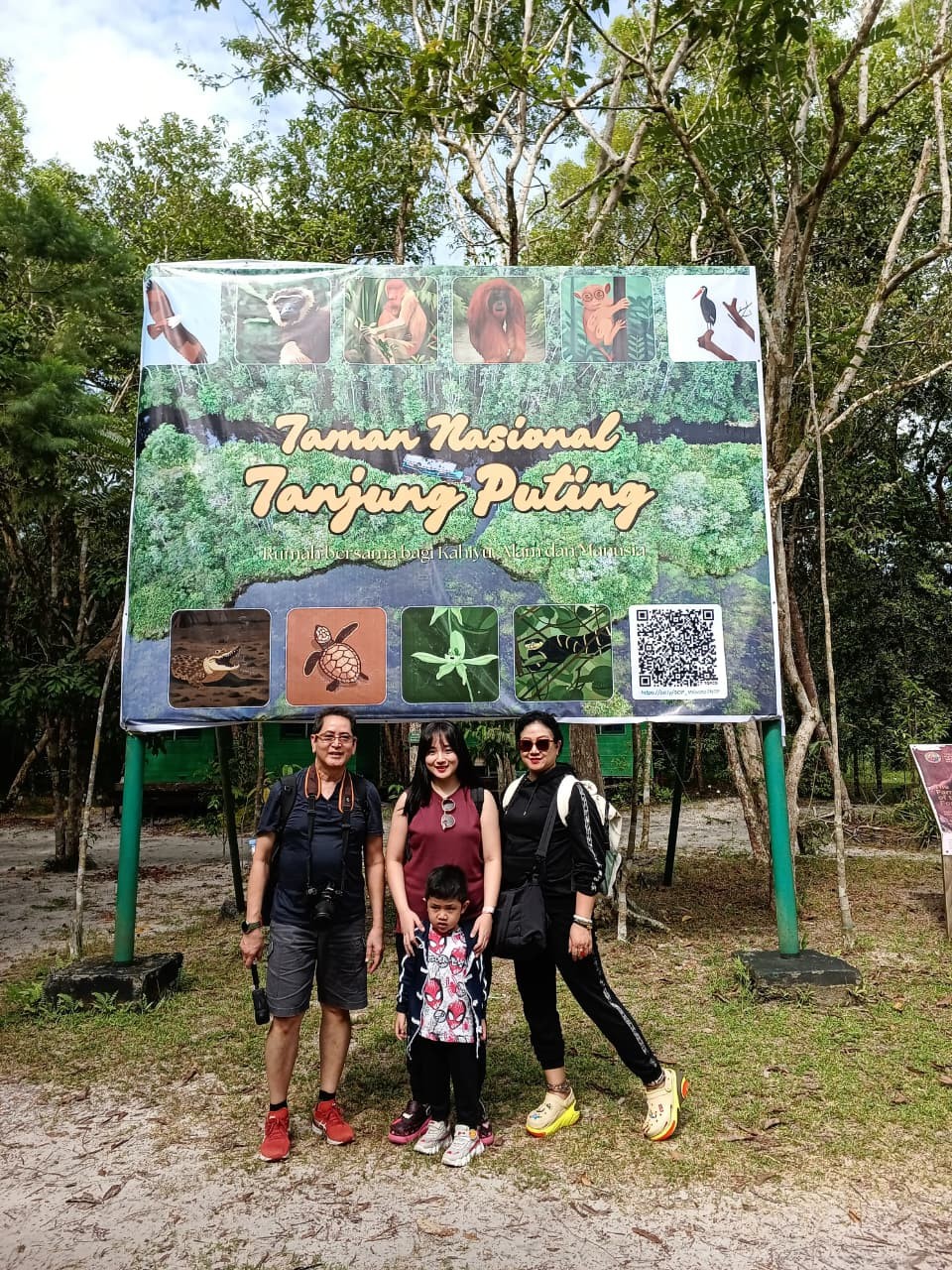 Foto keluarga di papan nama utama Taman Nasional Tanjung Puting.