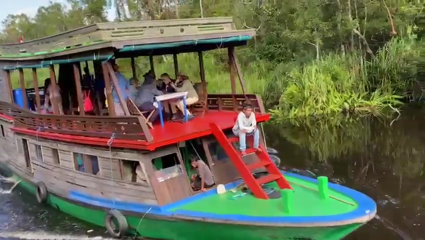 Bersantai di dek klotok kami saat berlayar menyusuri sungai yang tenang.