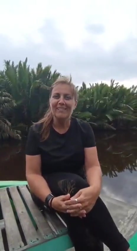 Tamu duduk nyaman di haluan klotok dengan tepi sungai pohon nipah yang meluncur berlalu.